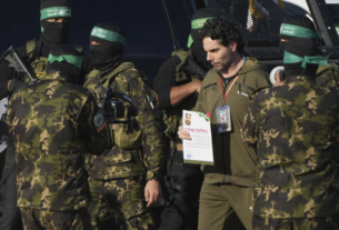 | Israeli Ofer Kalderon who has been held hostage by Hamas in Gaza since October 7, 2023, walks next to Hamas fighters before being handed over to the Red Cross by Hamas fighter in Khan Younis, southern Gaza Strip, Saturday Feb. 1, 2025. Photo/Abdel Kareem)